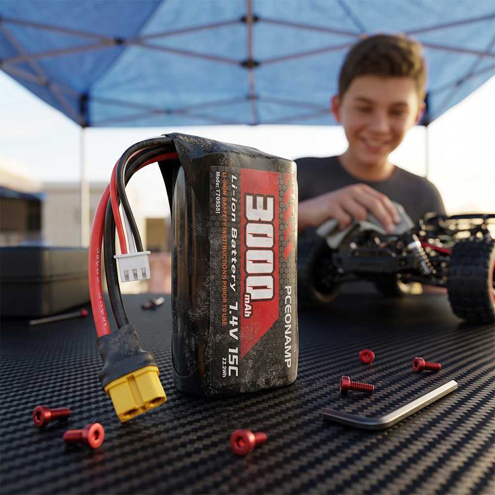 PCEONAMP 3000mAh 7.4V 2S Li-ion battery with XT60 plug in sharp focus on a carbon fiber surface, surrounded by red hex bolts and a hex wrench, with a smiling boy working on an RC buggy under a blue canopy tent in the soft-focus background.
